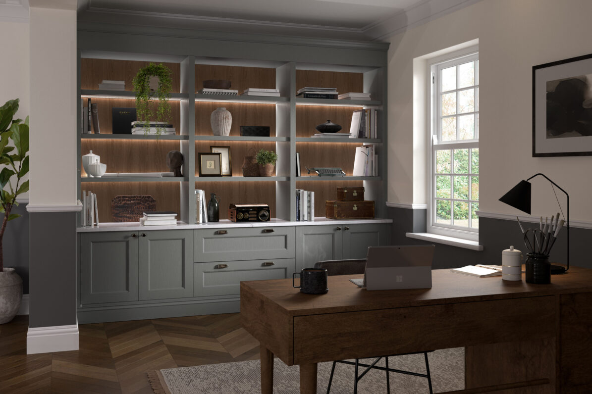Gently lit open bookcase in light grey pastel colour with file drawers beneath and desk area in front
