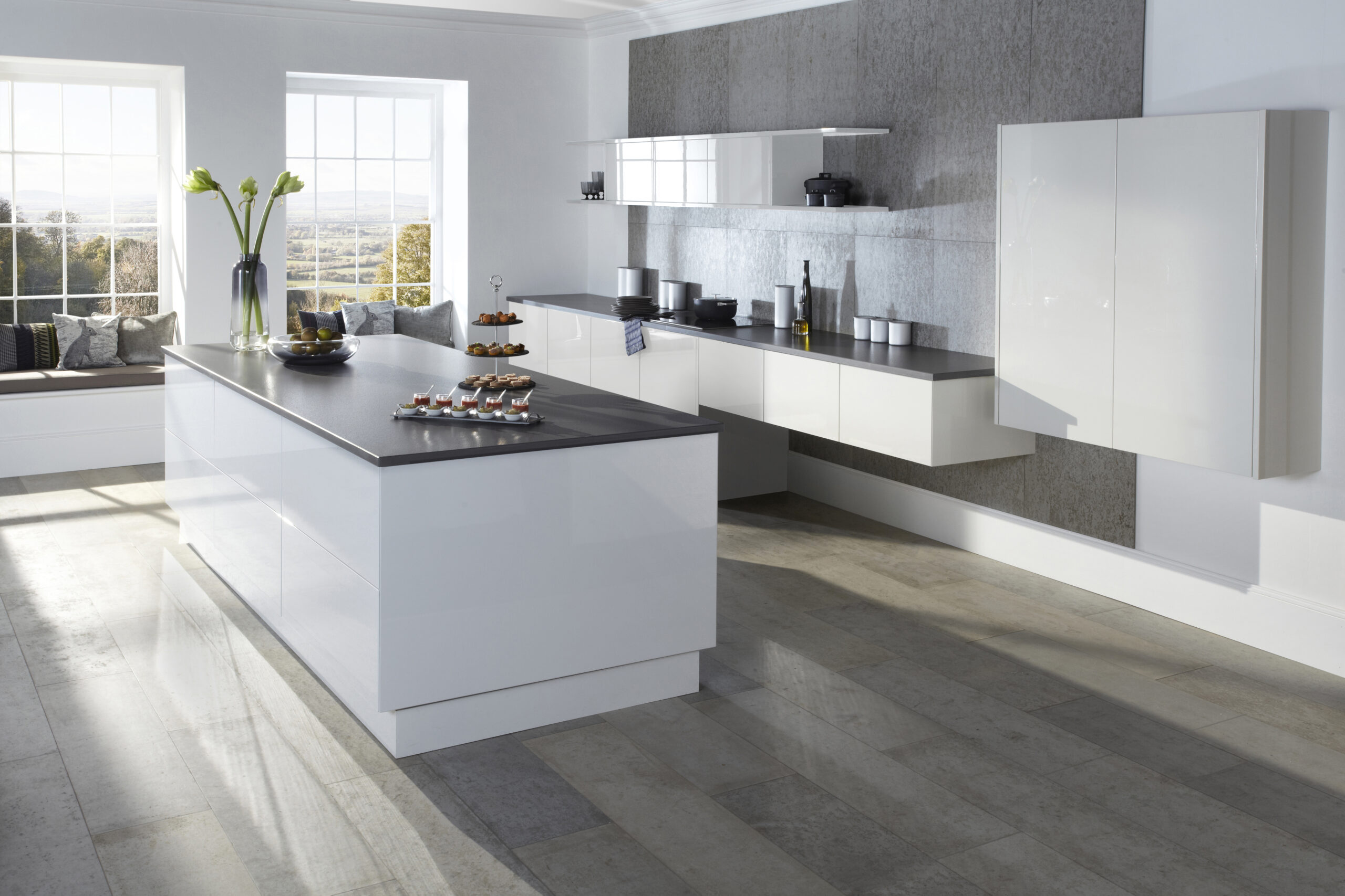 gloss white kitchen design with island and grey surface , wall hung suspended base cabinets to rear