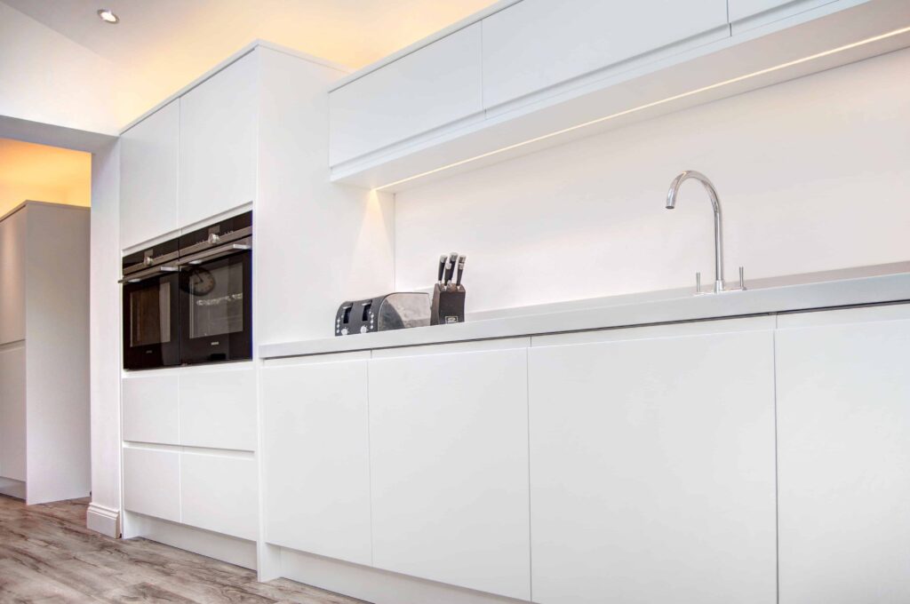 White fitted kitchen in Middlesbrough, units with two oven towers and short height wall cabinets with flat cabinet doors