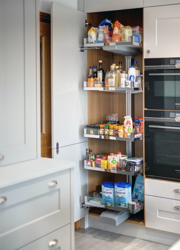 Fitted kitchen in Dove grey with tandem pull-out full height larder cabinet shown to left of an oven tower