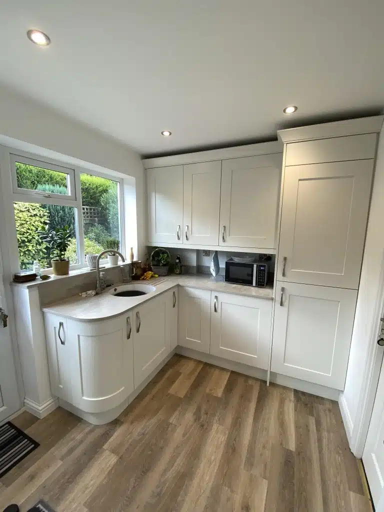 Sleek Stylish Kitchen Designed And Installed 2 curved base cabinet in a utility room and wash up sink with wall cabinet storage in pale cream