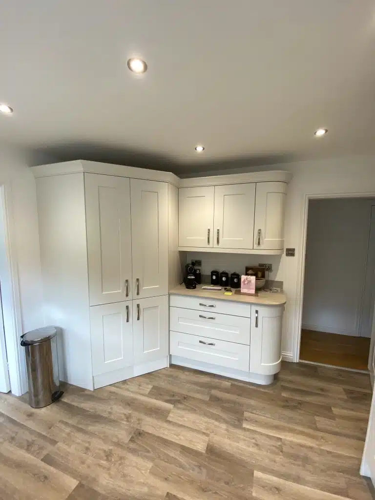 diagonal larder tower with cabinets to the right hand side finishing with curved bases top and bottom all in pale cream